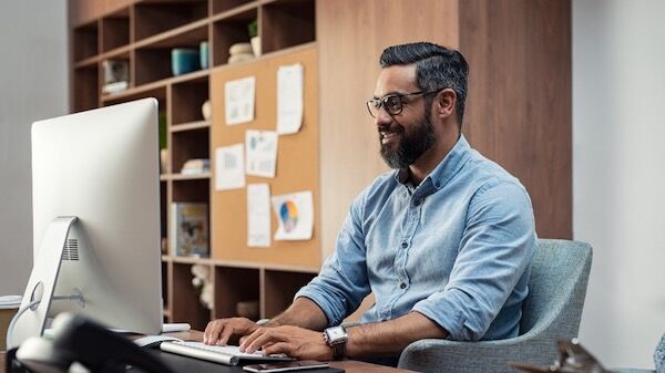 A person sitting at a desk in front of a computer
