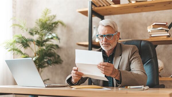 A person sitting at a desk looking at a piece of paper