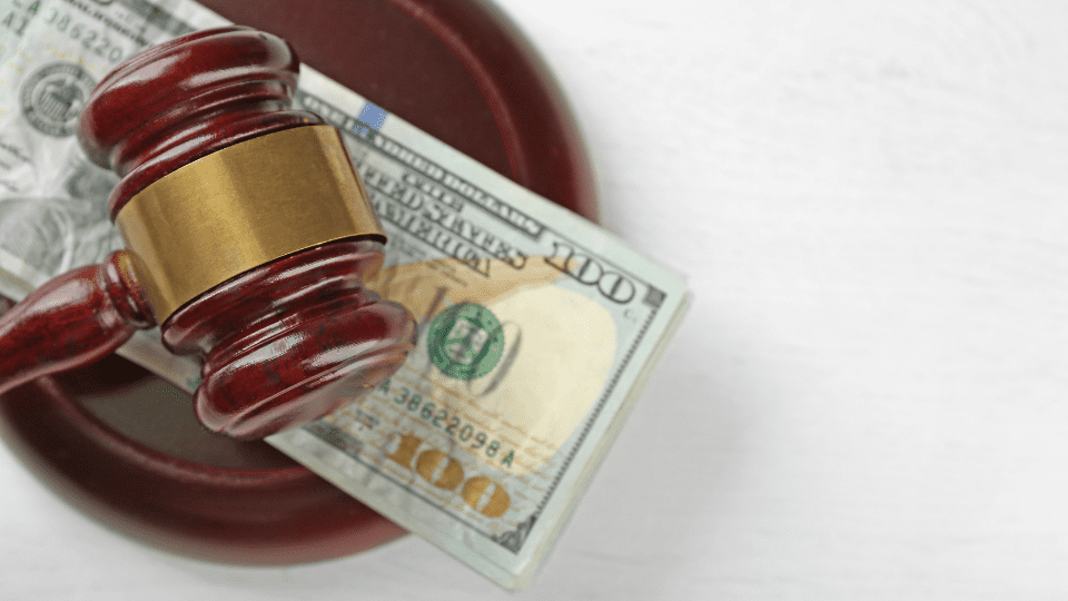 A judge's gavel on top of a stack of money