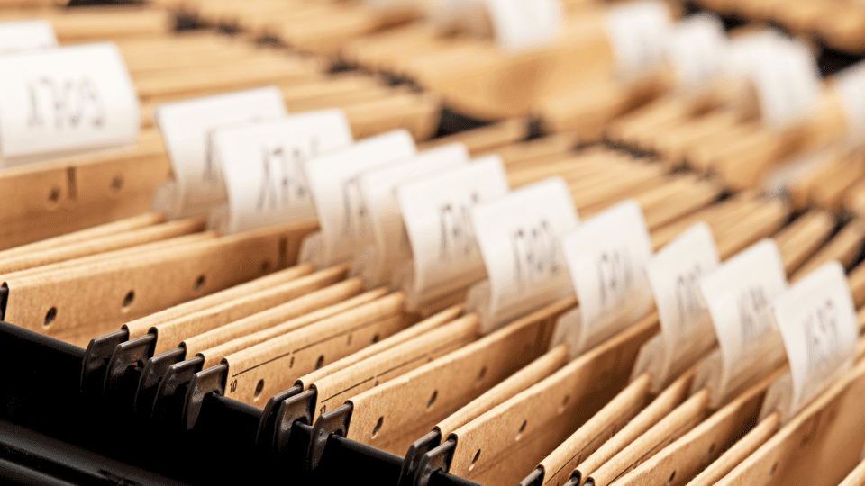 A close-up of a row of file folders with labels on them