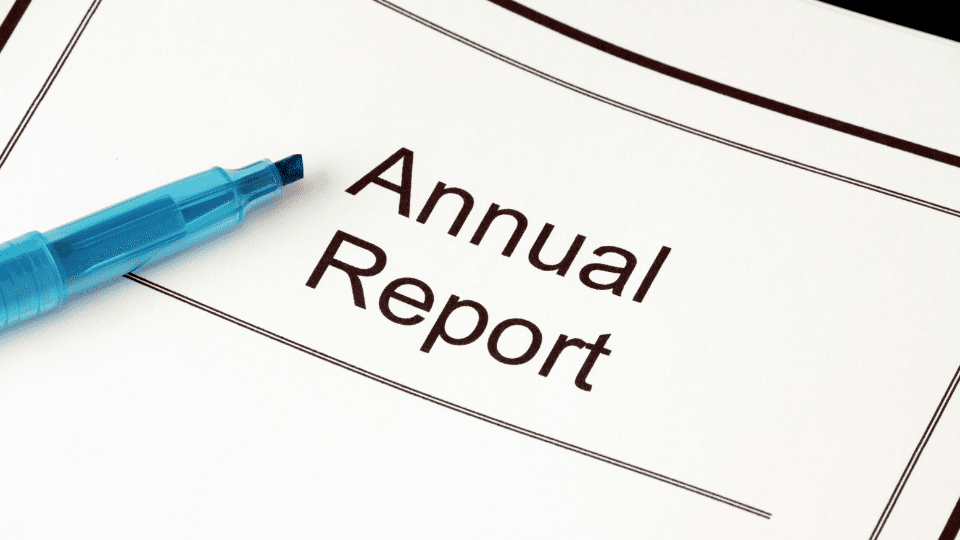 A close-up picture of an annual report with a blue highlighter sitting on top of it