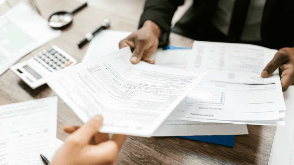 One person handing official business documents to another