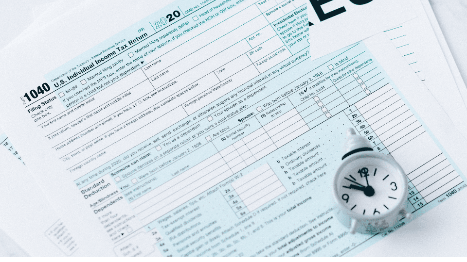 Income tax return papers for filing with a small stopwatch.